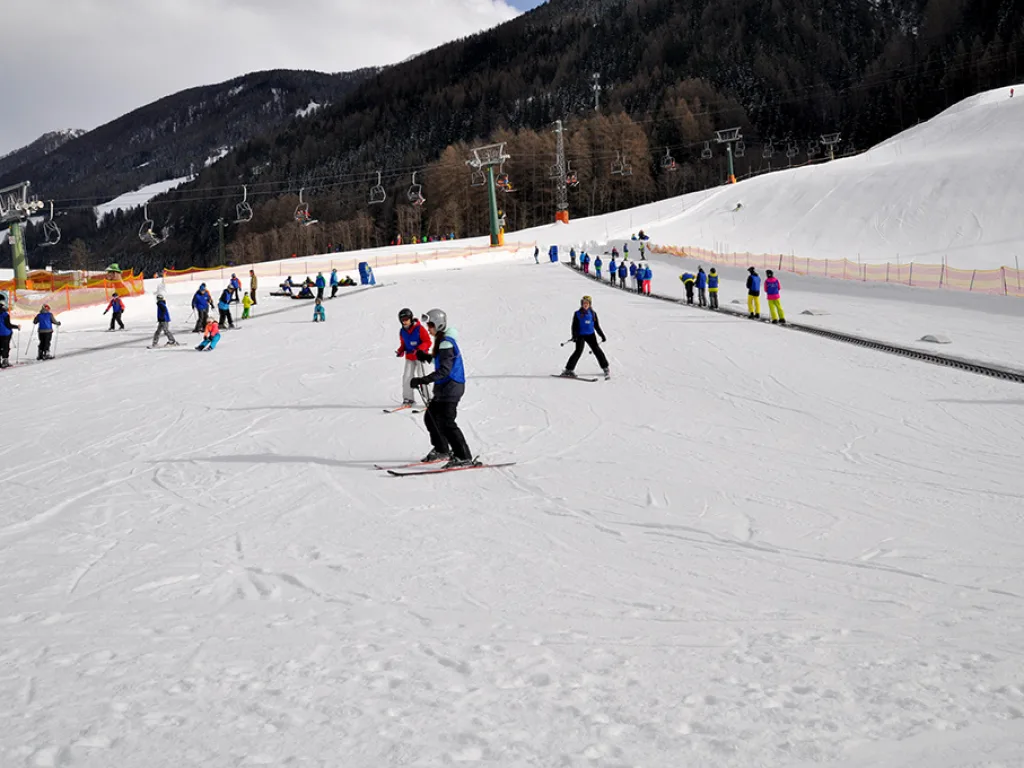 Blick über die Piste mit einzelnen Fahrenden vor dem Lift.